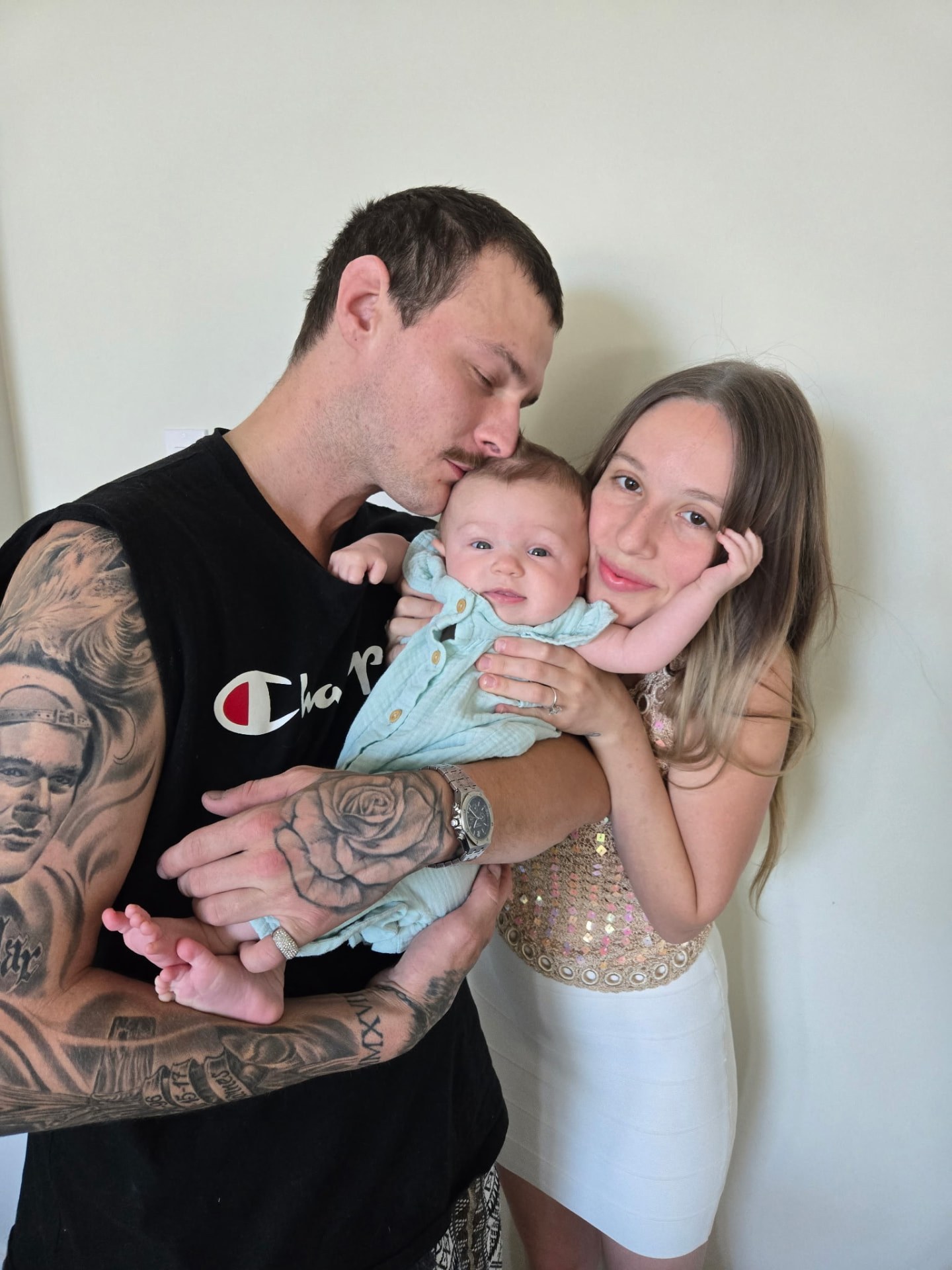 Travis and Annica cuddling their baby